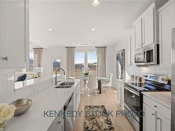 a kitchen with counter top space a sink appliances and cabinets