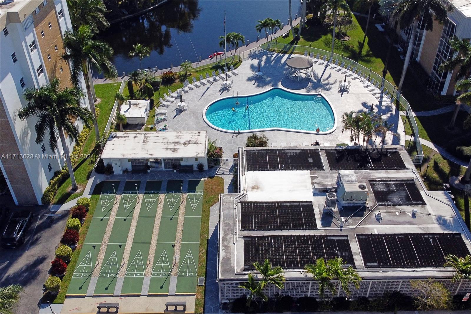 an aerial view of a swimming pool with outdoor seating