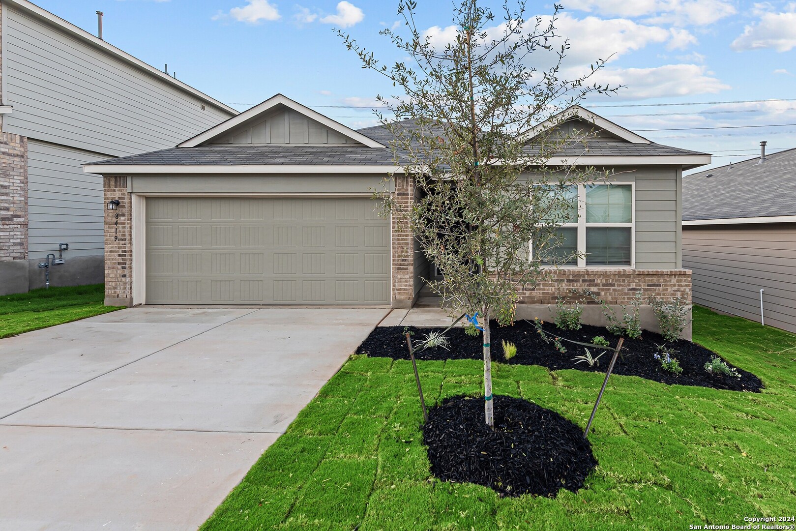 a front view of a house with a yard and garage