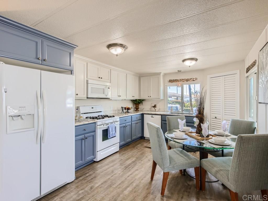 a kitchen with a table chairs a sink dishwasher window and cabinets