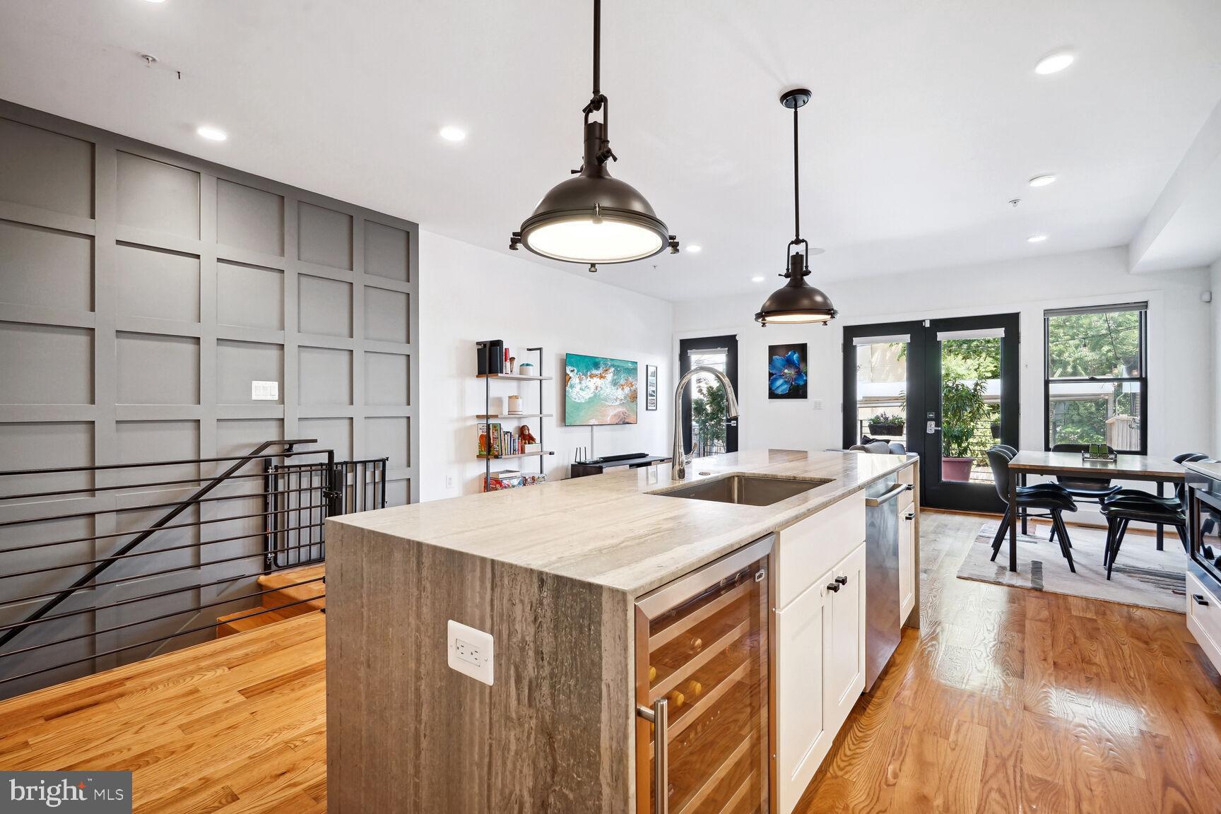 a kitchen with stainless steel appliances granite countertop a sink a stove and a wooden floors