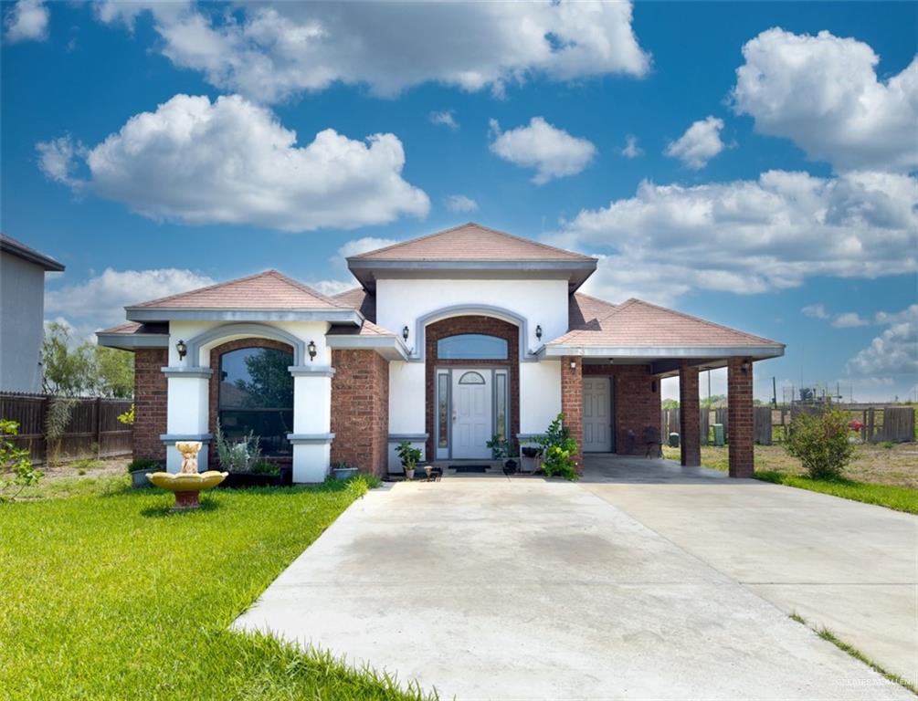 View of front of home with a carport and a front yard