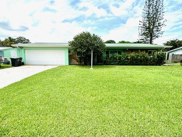 a front view of a house with a yard and trees