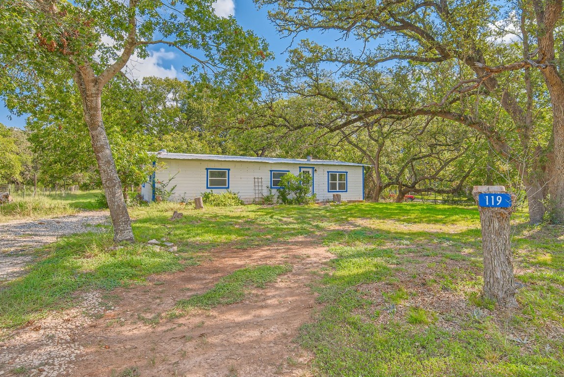 a front view of a house with a yard and trees