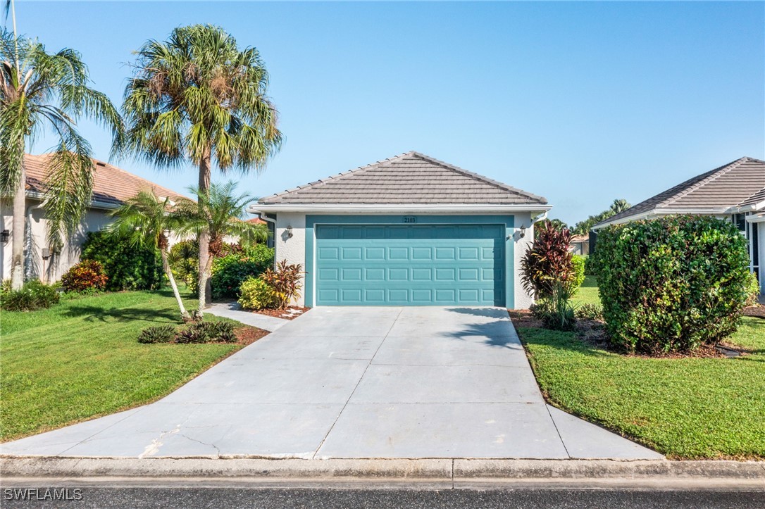 front view of a house with a yard and palm trees