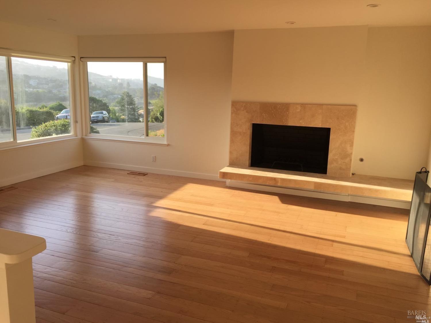 a room with wooden floor and a fireplace