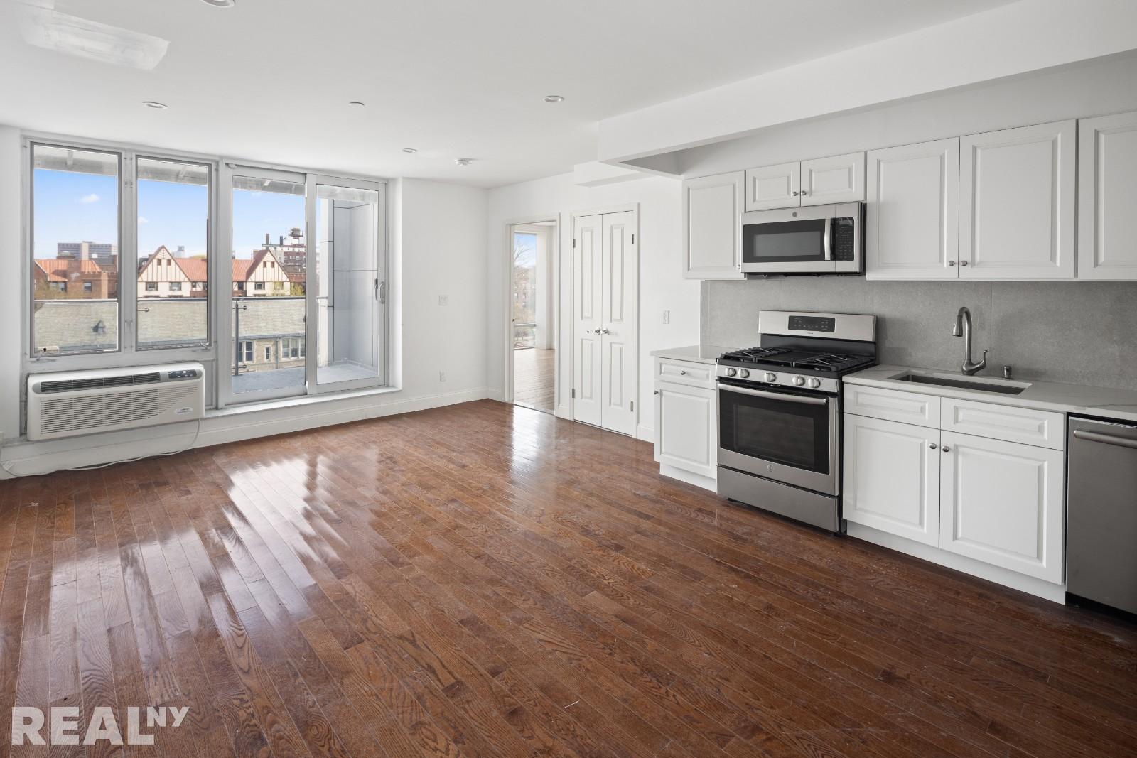 a kitchen with stainless steel appliances a stove top oven and a refrigerator