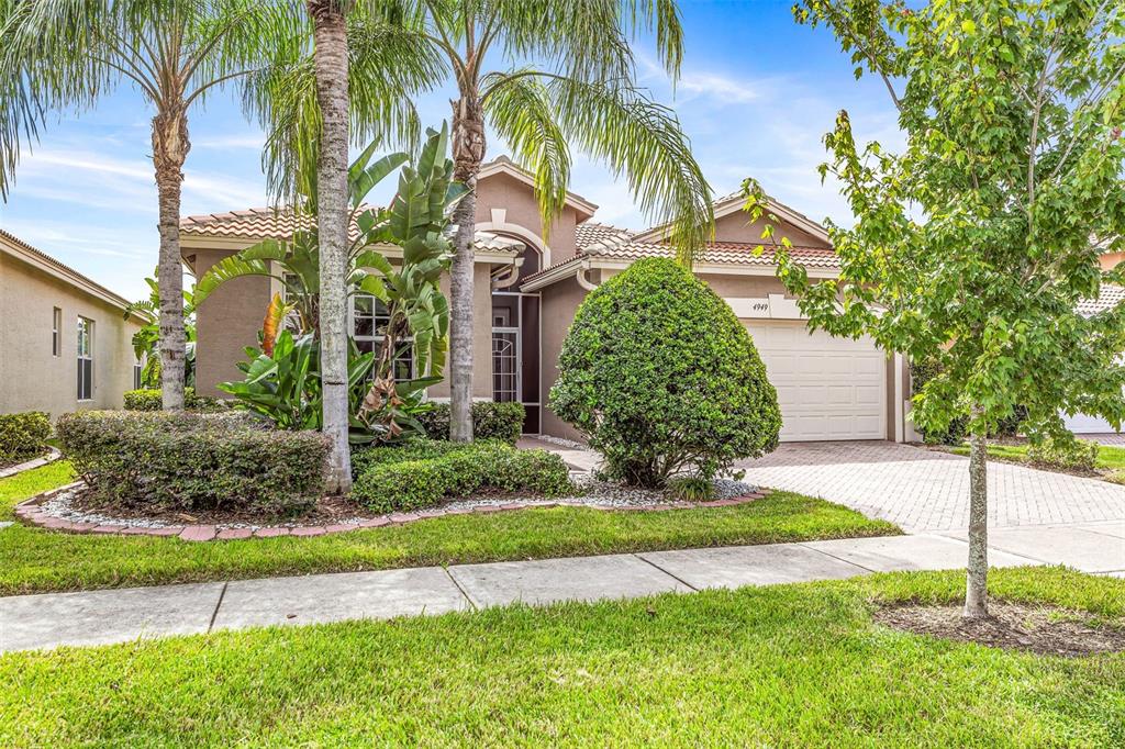 a view of a house with a yard and palm trees