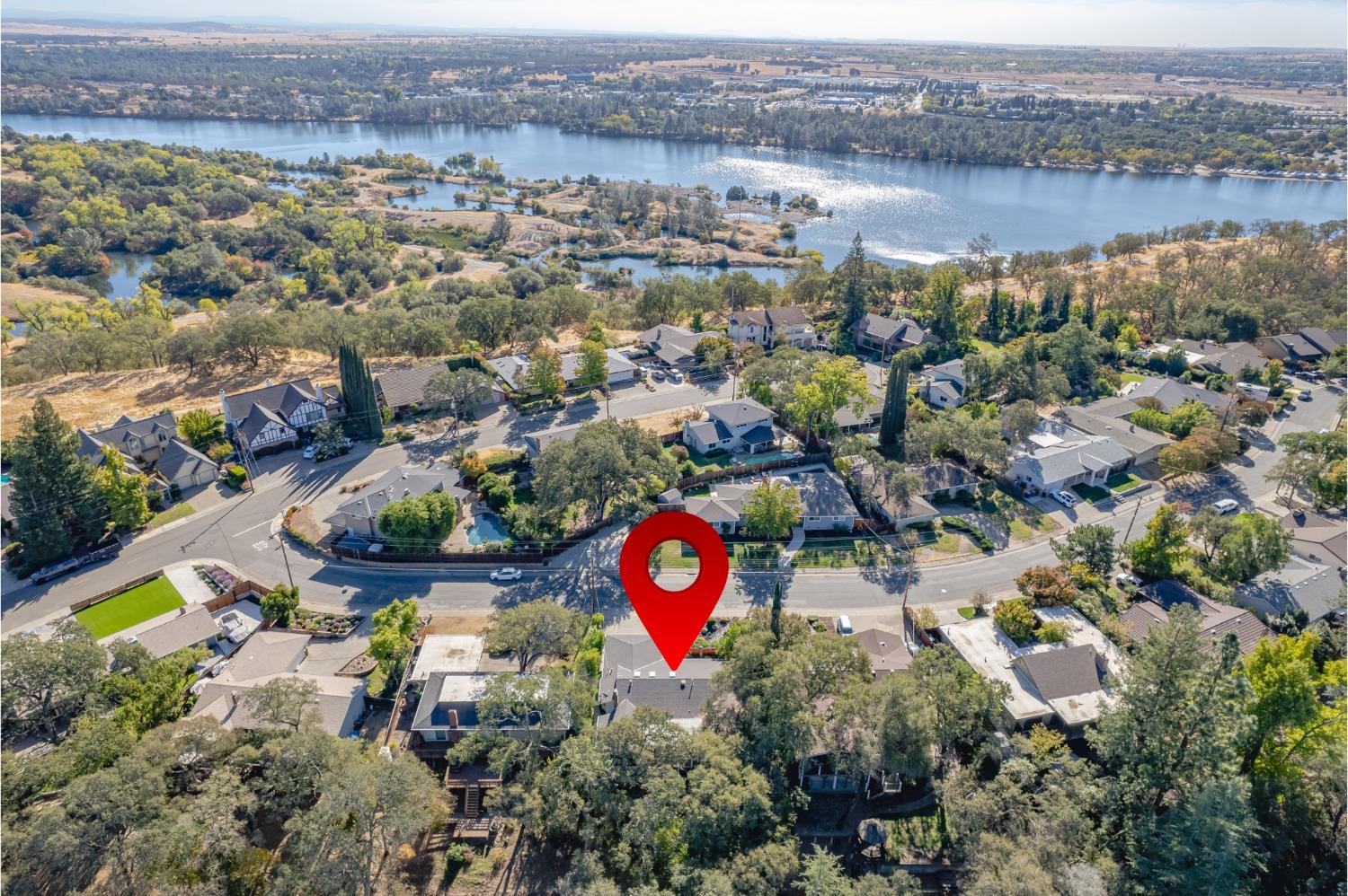 an aerial view of a house with a yard and lake view