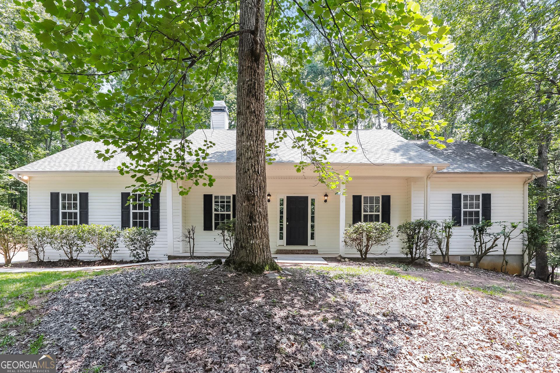 a front view of house with yard and trees around