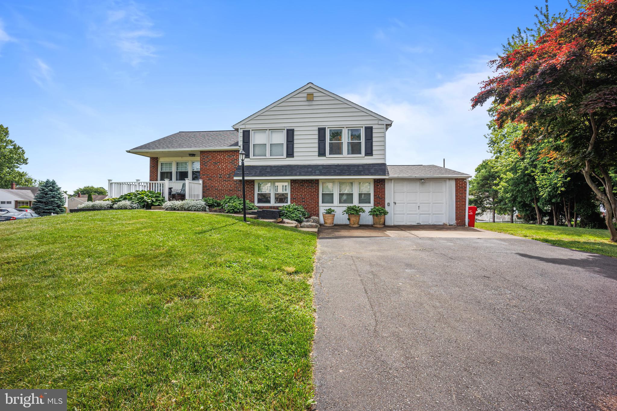 a front view of a house with a yard and green space