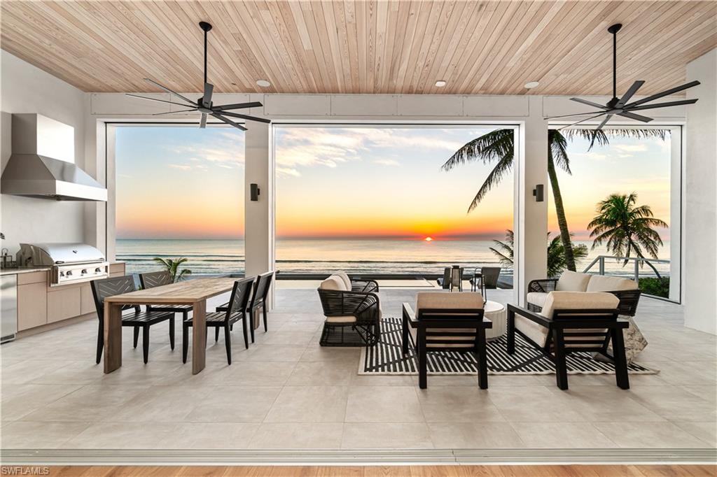 a dining room with furniture water view and a floor to ceiling window