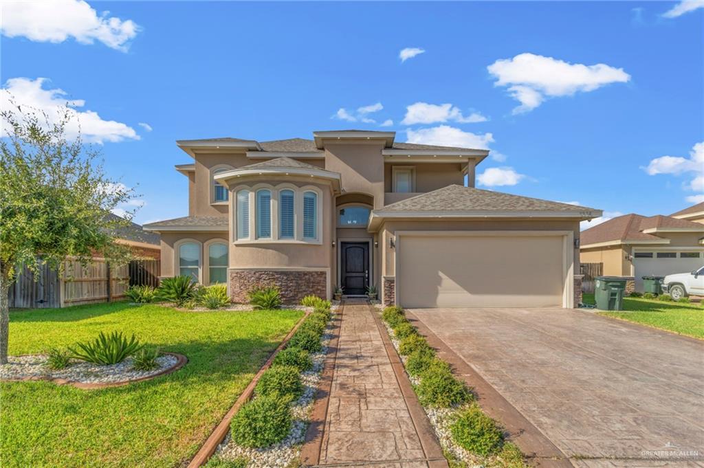 a front view of a house with a yard and garage