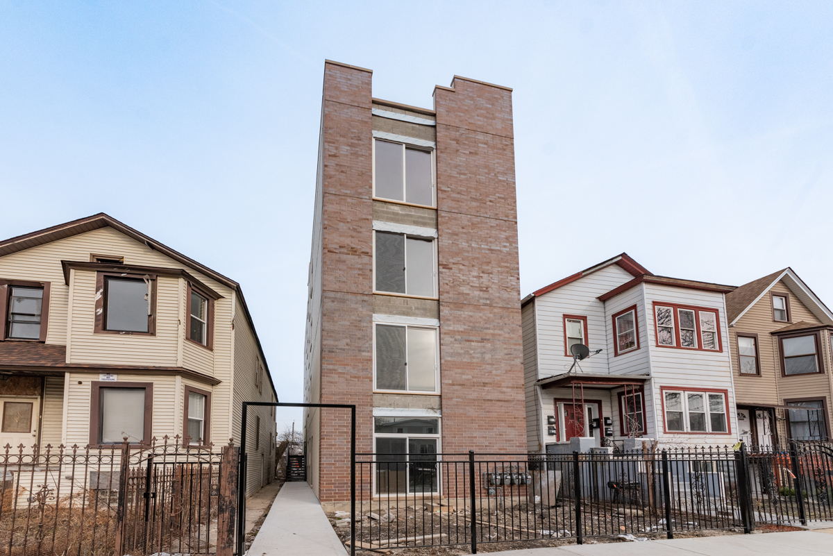 a view of a brick building next to a yard