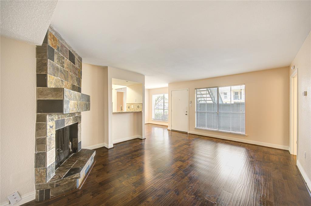 an empty room with wooden floor and fireplace