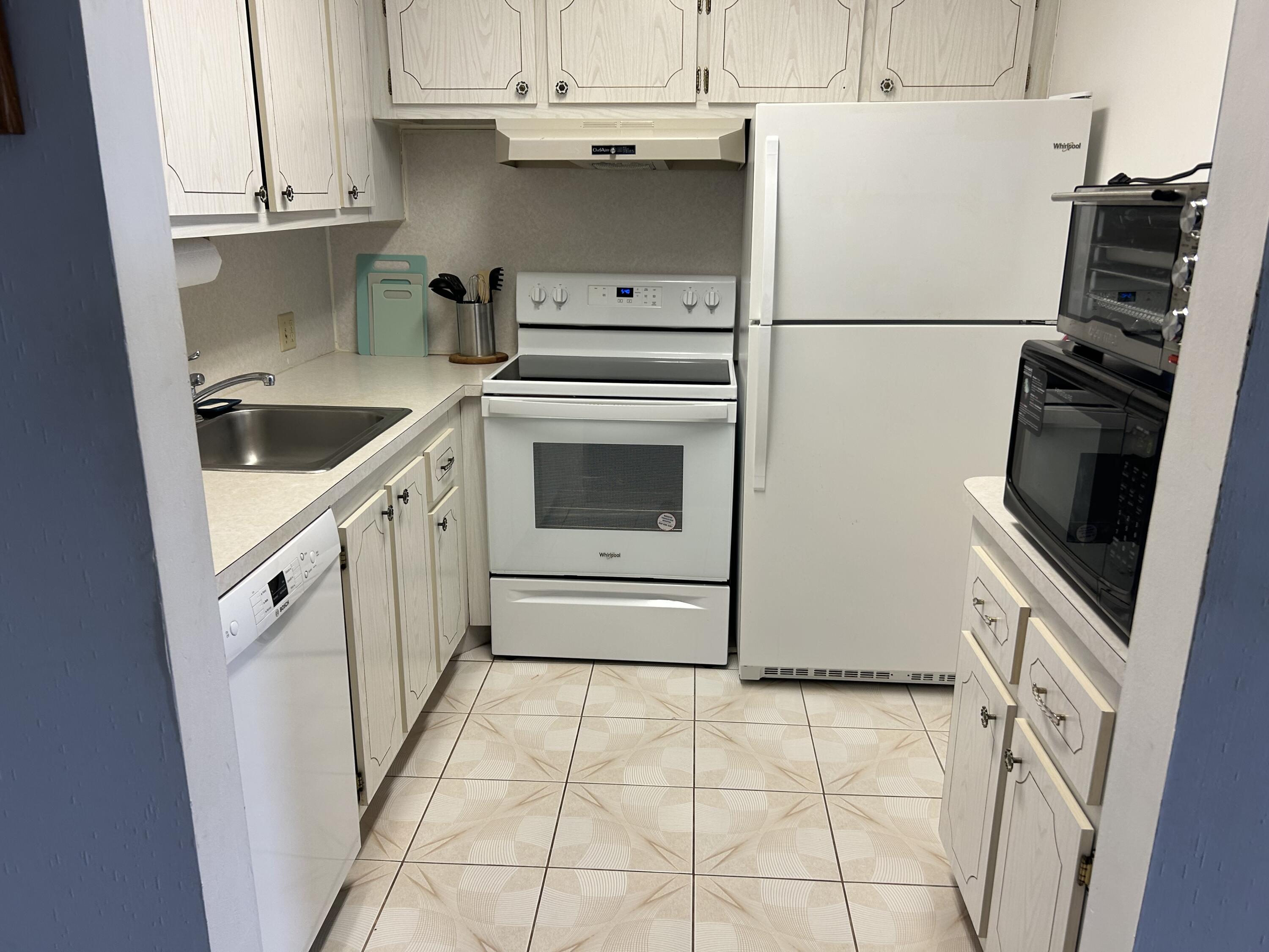 a kitchen with white cabinets and white appliances