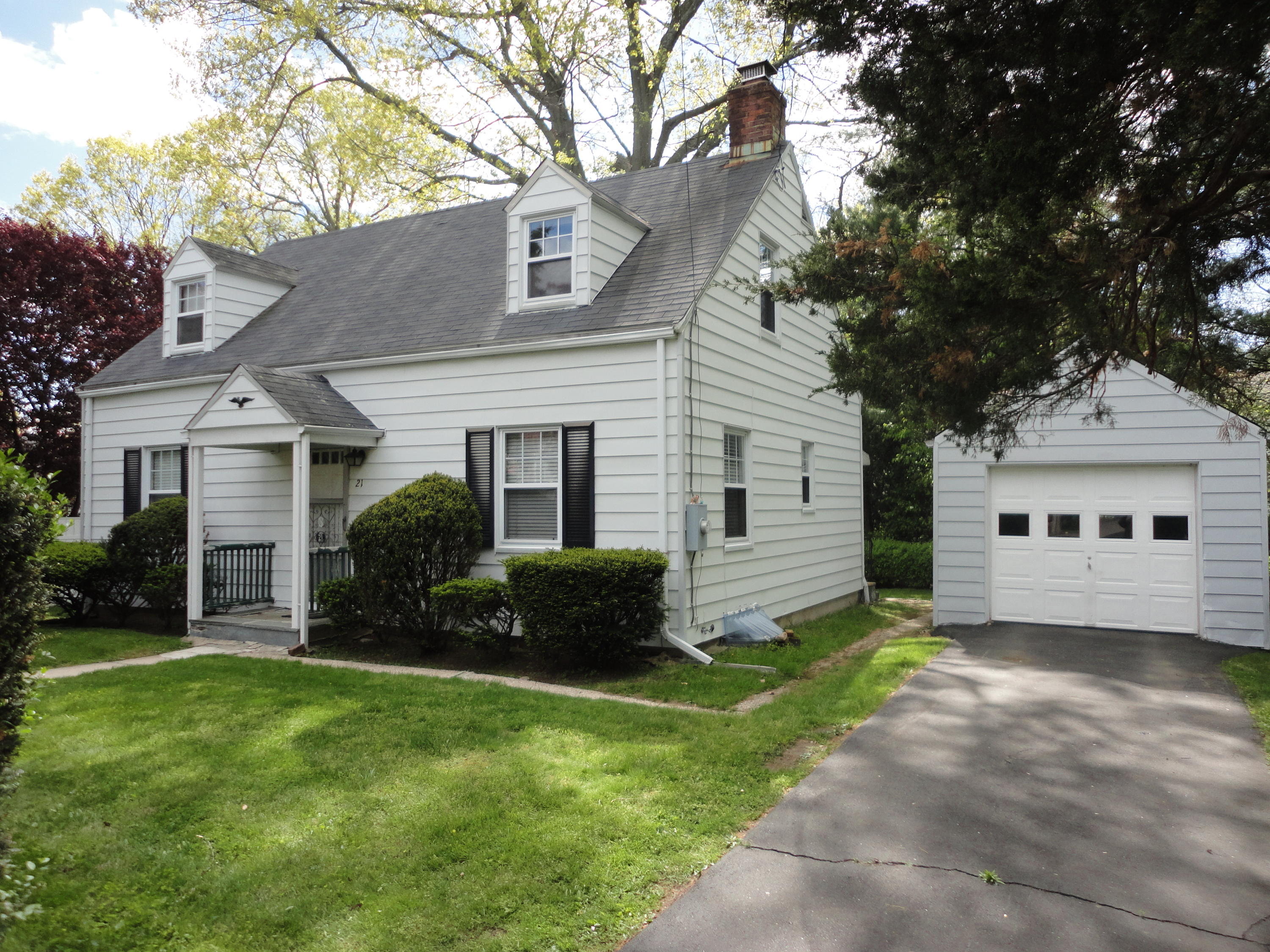 a view of a house with a yard and a large tree