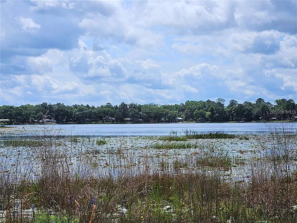 a view of lake with green landscape