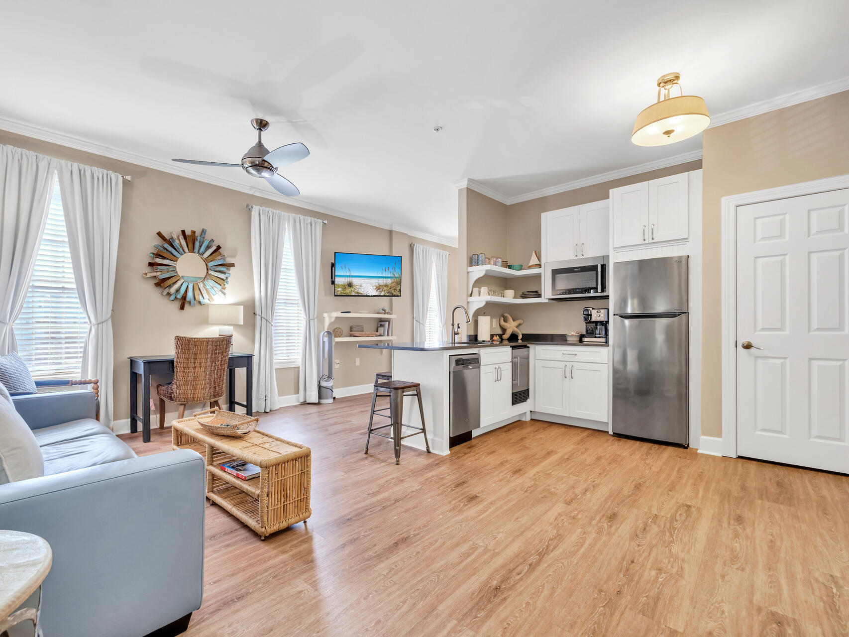 a living room with stainless steel appliances kitchen island granite countertop furniture and a wooden floor