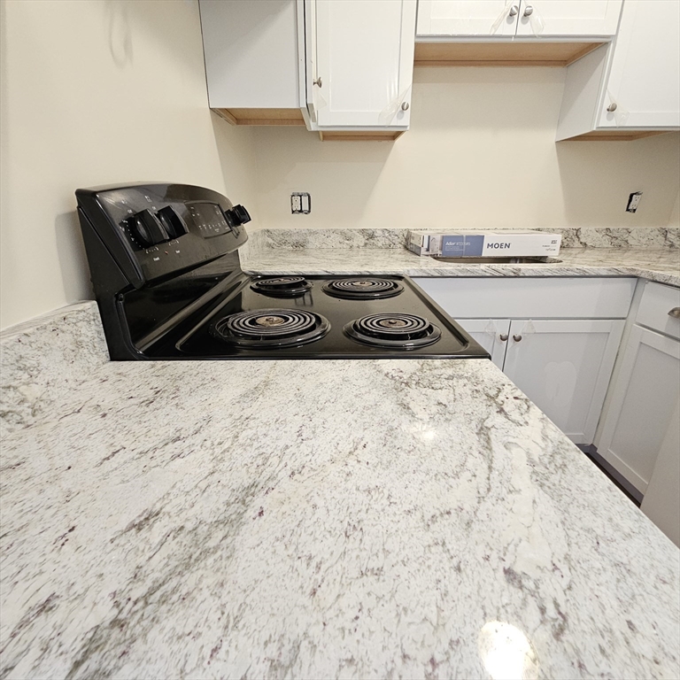 a kitchen with a stove a sink and a cabinets