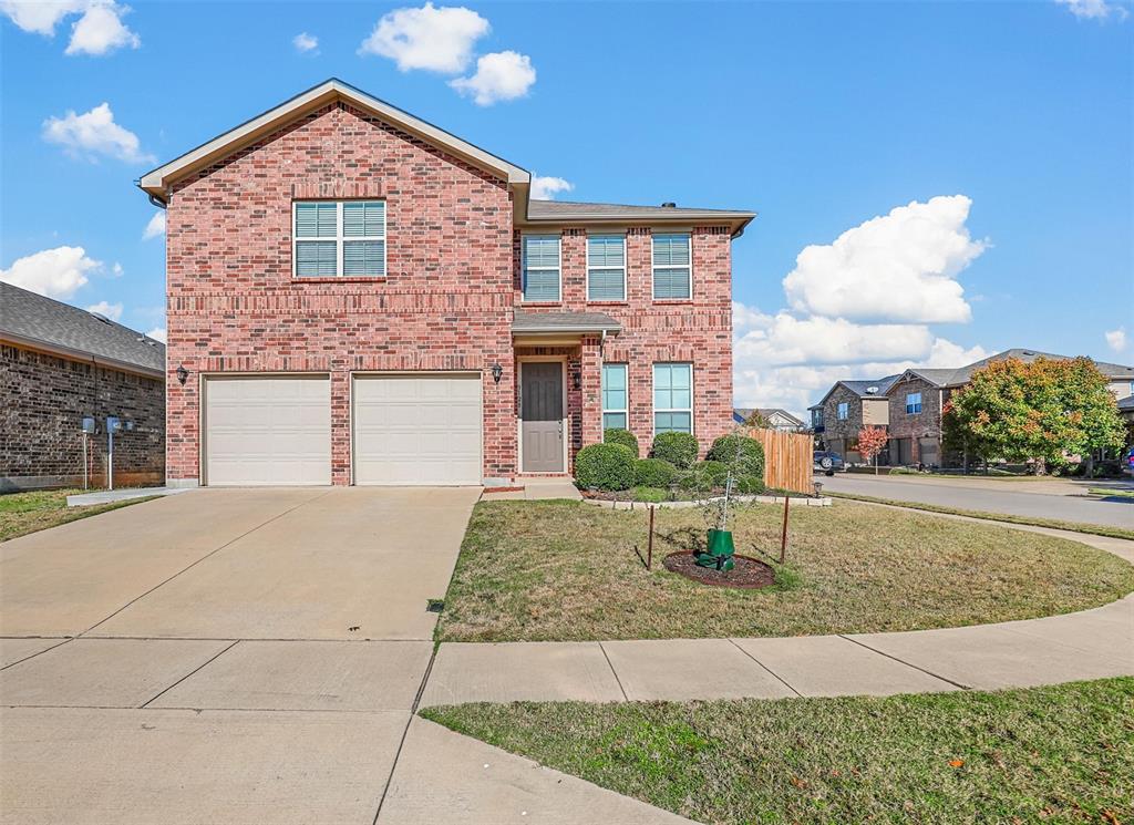 Front of property featuring a beautifully landscaped corner lot and a two car garage