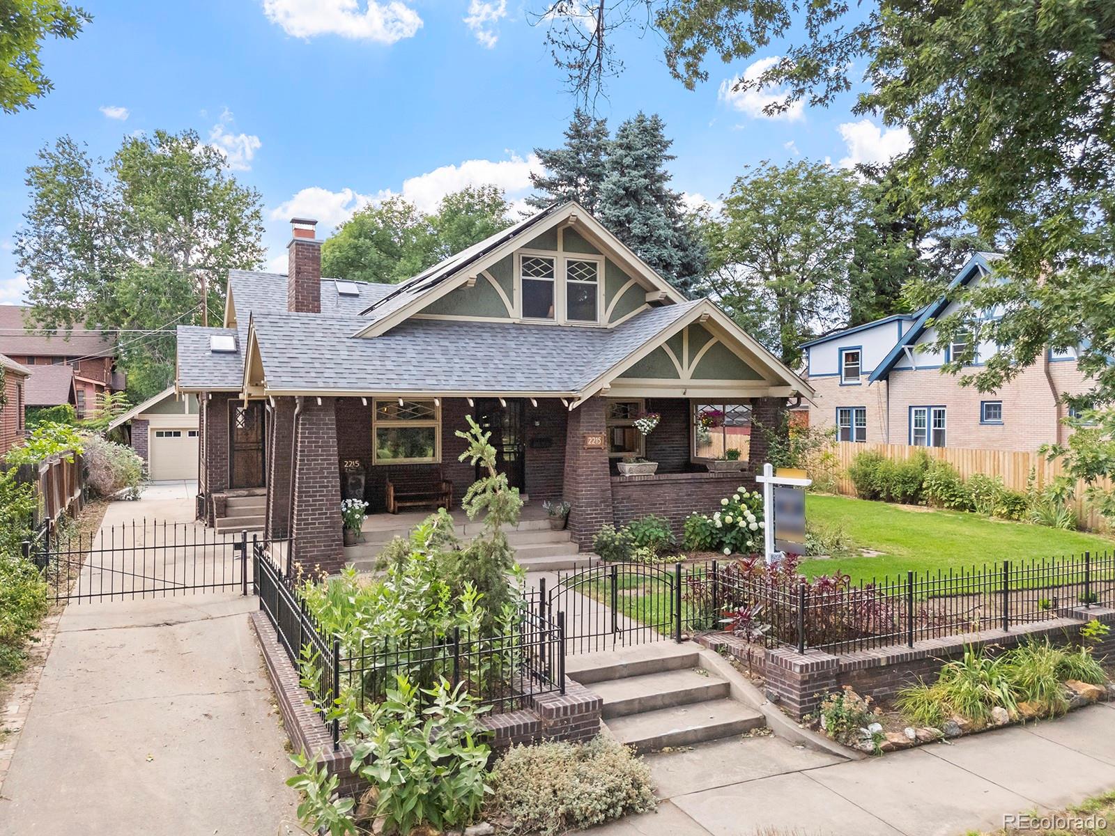 a front view of a house with a yard and potted plants