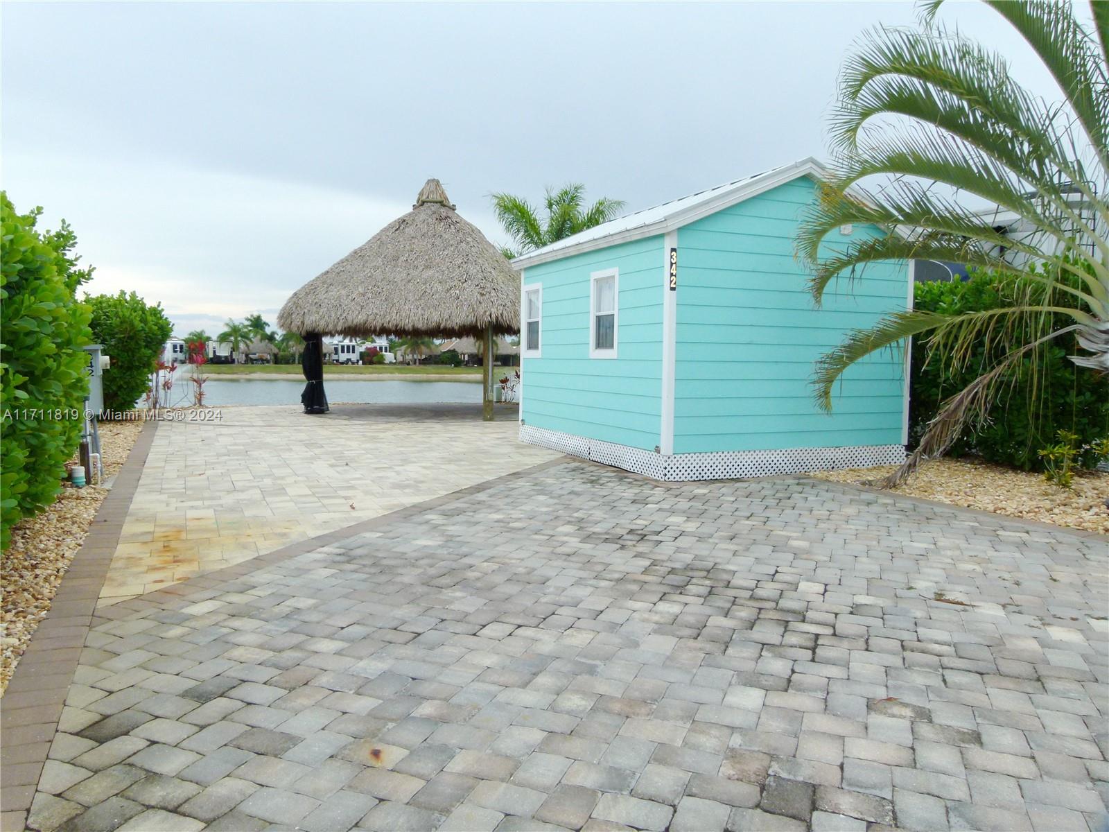 a view of a house with a backyard and bushes