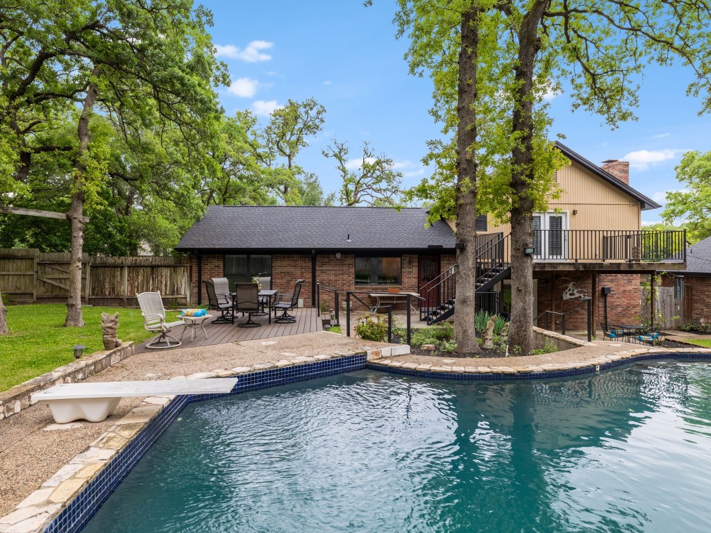 a view of a house with swimming pool and sitting area