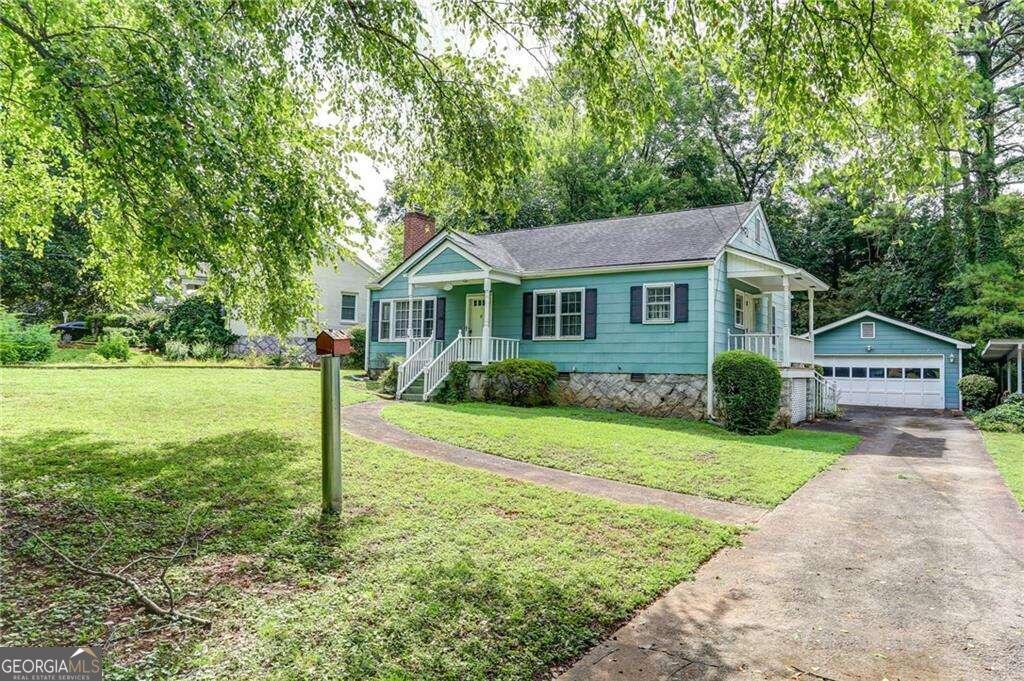 a front view of a house with a yard and trees