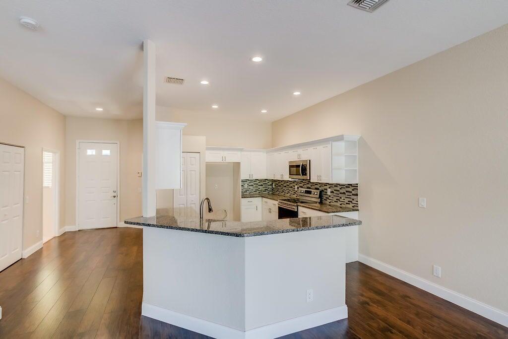 a kitchen with stainless steel appliances granite countertop a sink and a stove top oven