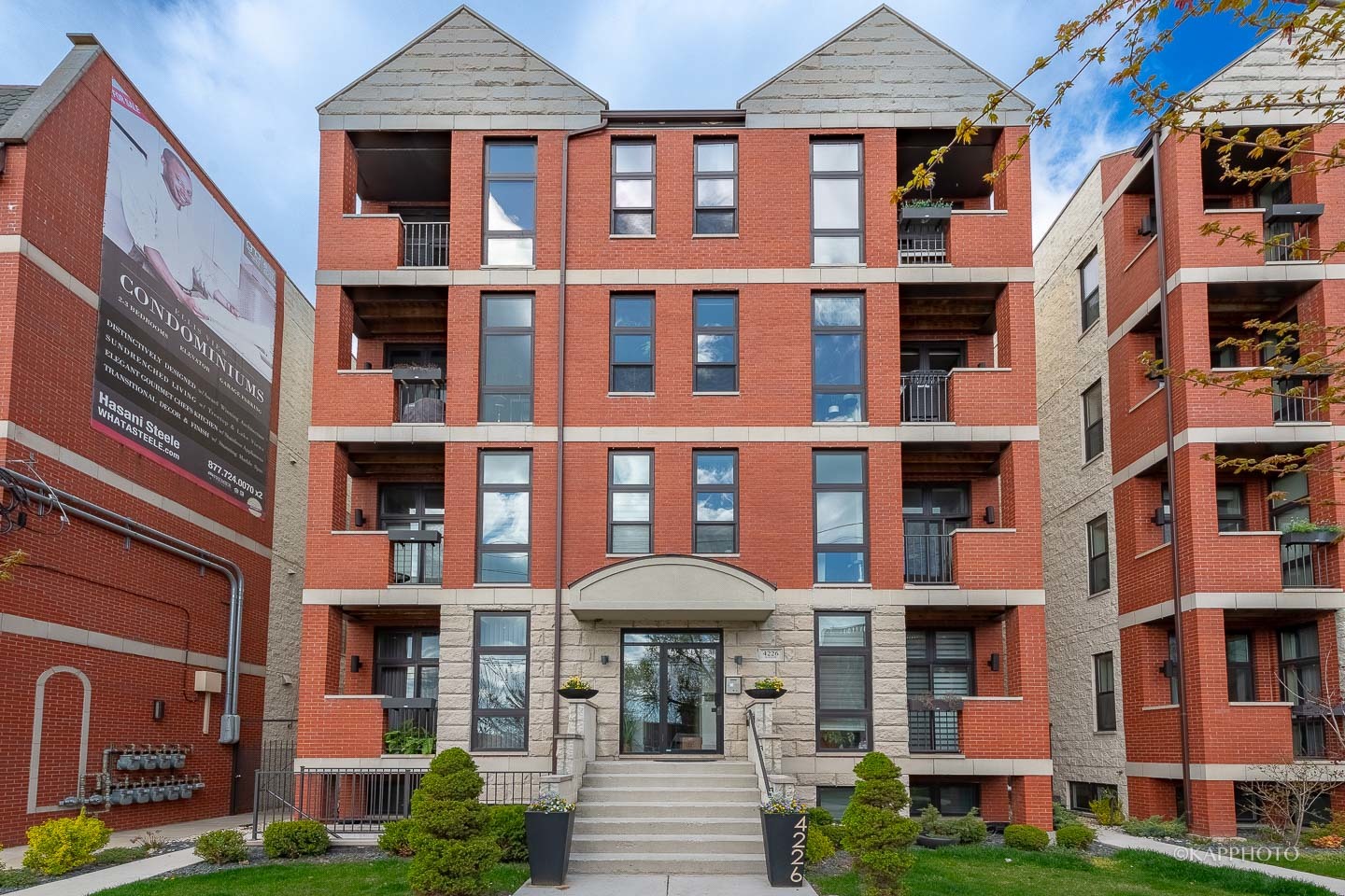 a front view of a brick building next to a yard