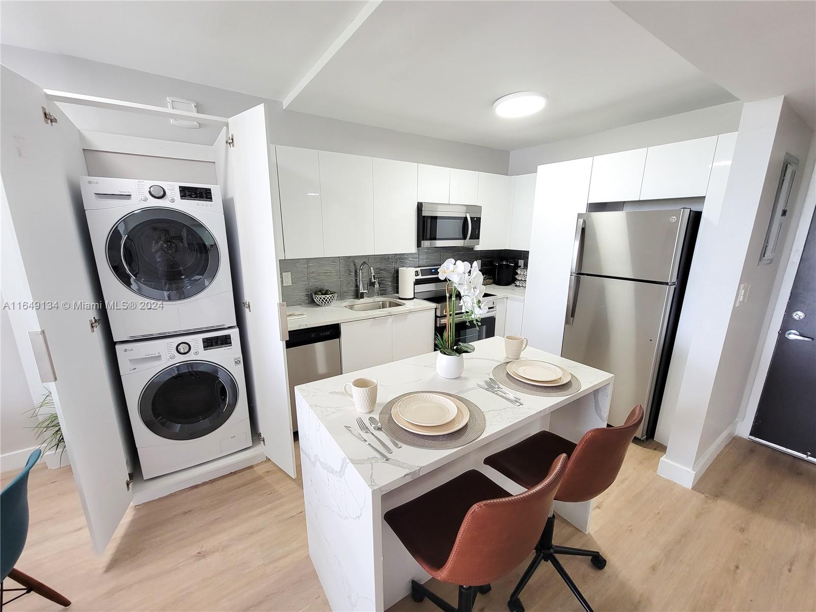 a kitchen with a table chairs a stove a microwave and a refrigerator