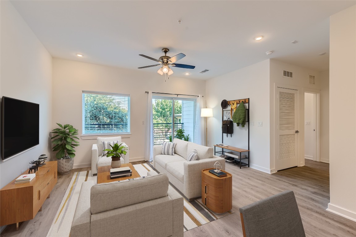 a living room with furniture a flat screen tv and a large window