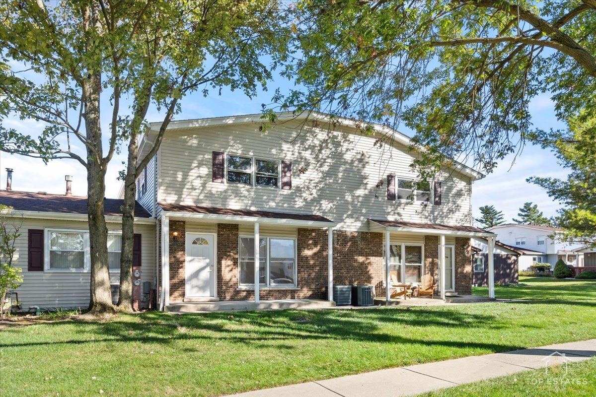 front view of a brick house with a yard