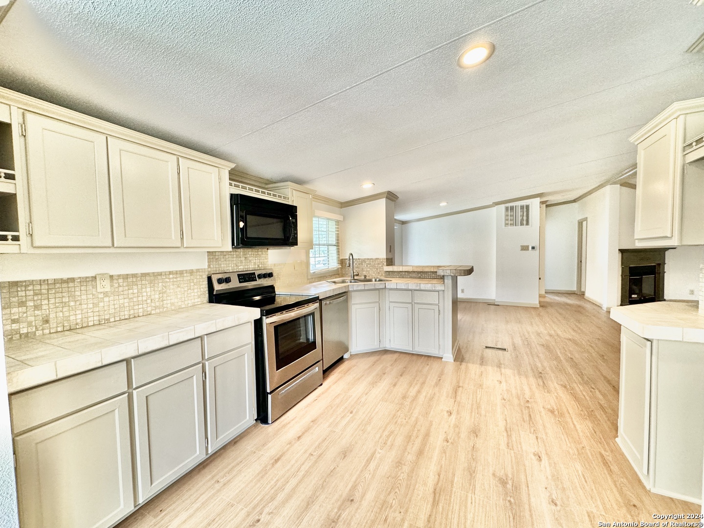 a kitchen with granite countertop a sink cabinets and stainless steel appliances