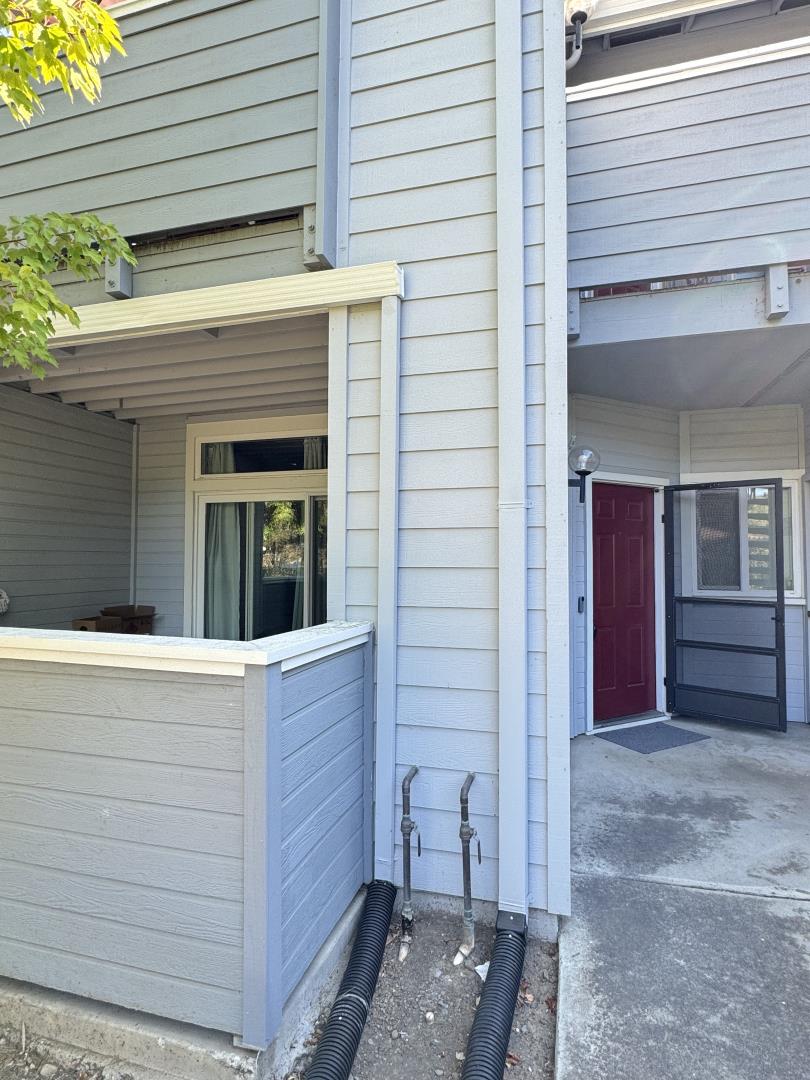 a view of a house with a door and wooden bench