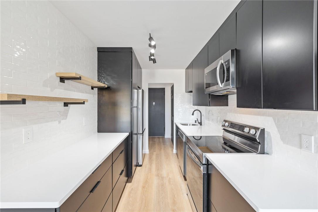 a kitchen with granite countertop a sink and refrigerator