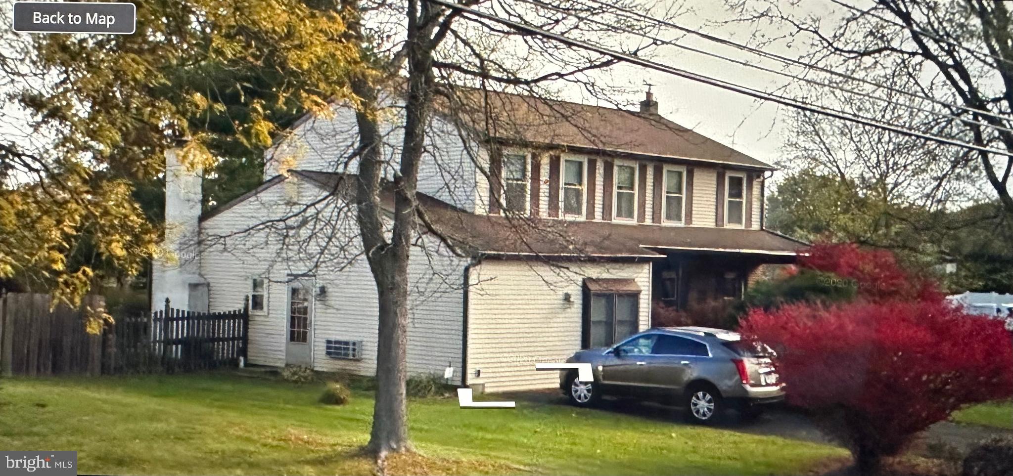 a front view of a house with a garden and trees