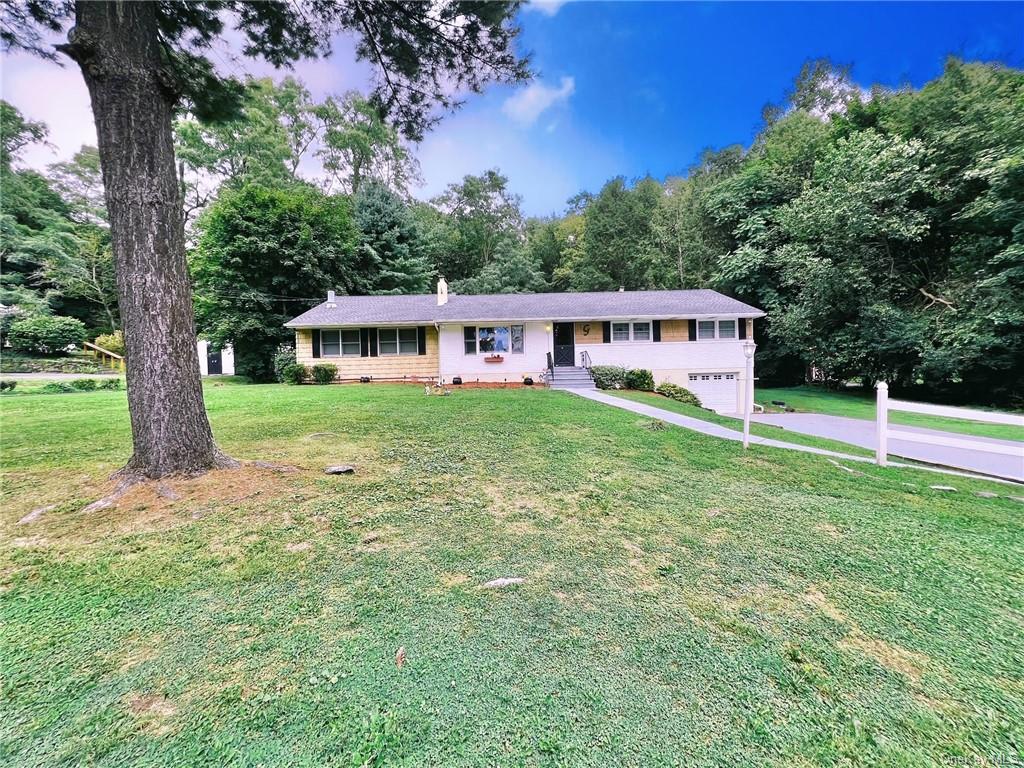 a view of a house with backyard and trees