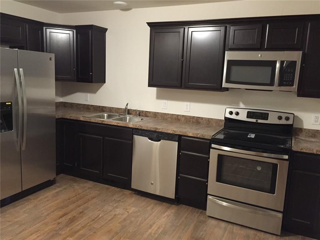 a kitchen with stainless steel appliances granite countertop a stove microwave and refrigerator