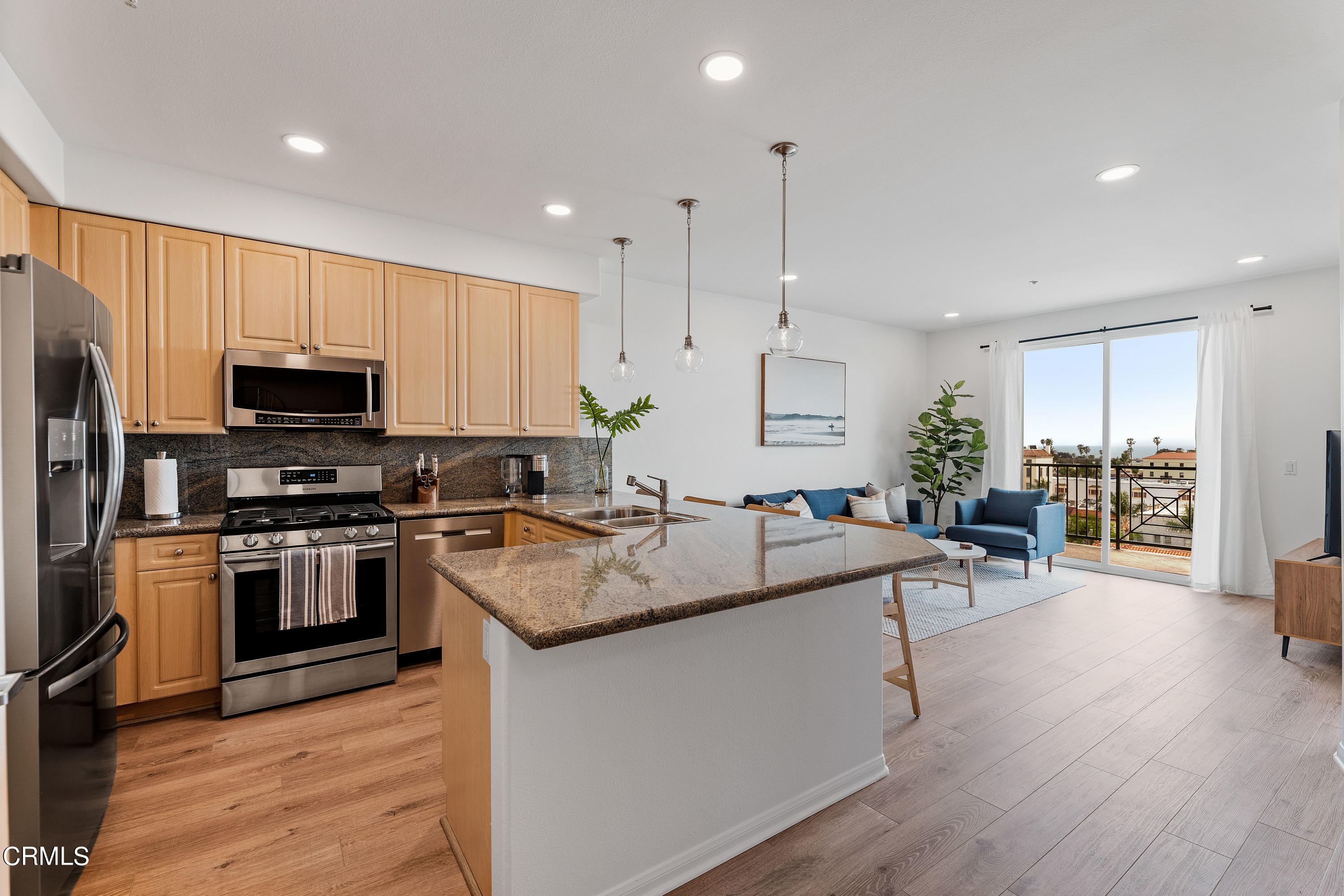 a kitchen with a sink a counter top space stainless steel appliances and cabinets