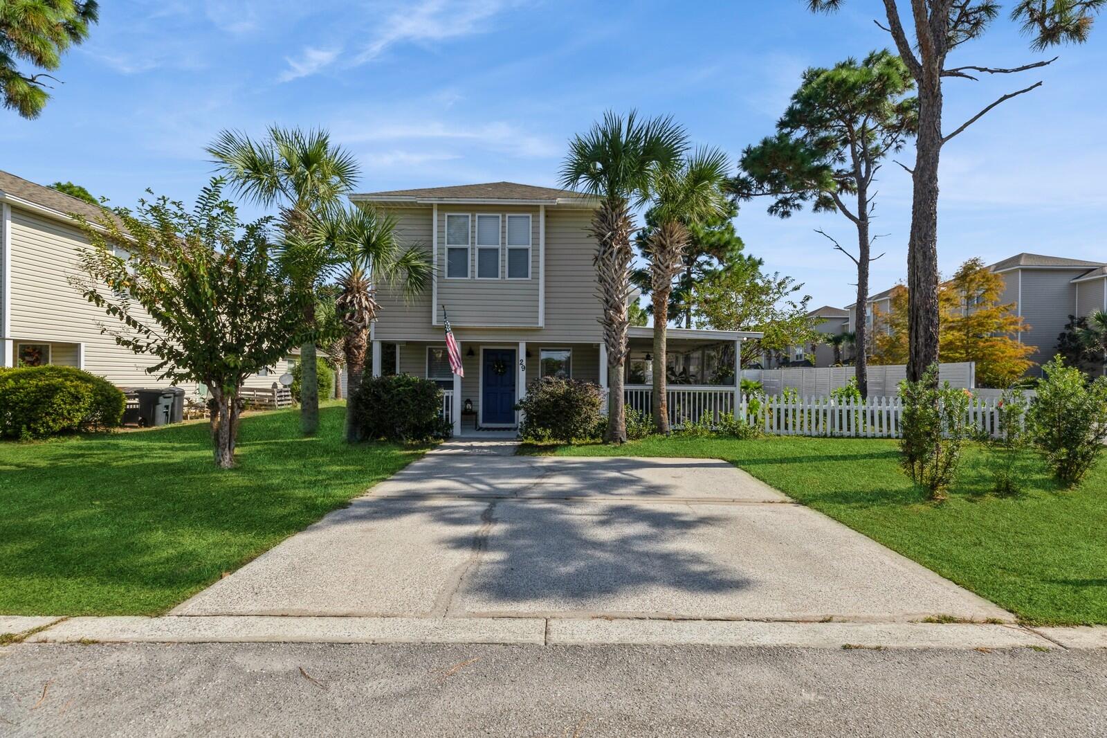 a front view of a house with a yard and potted plants