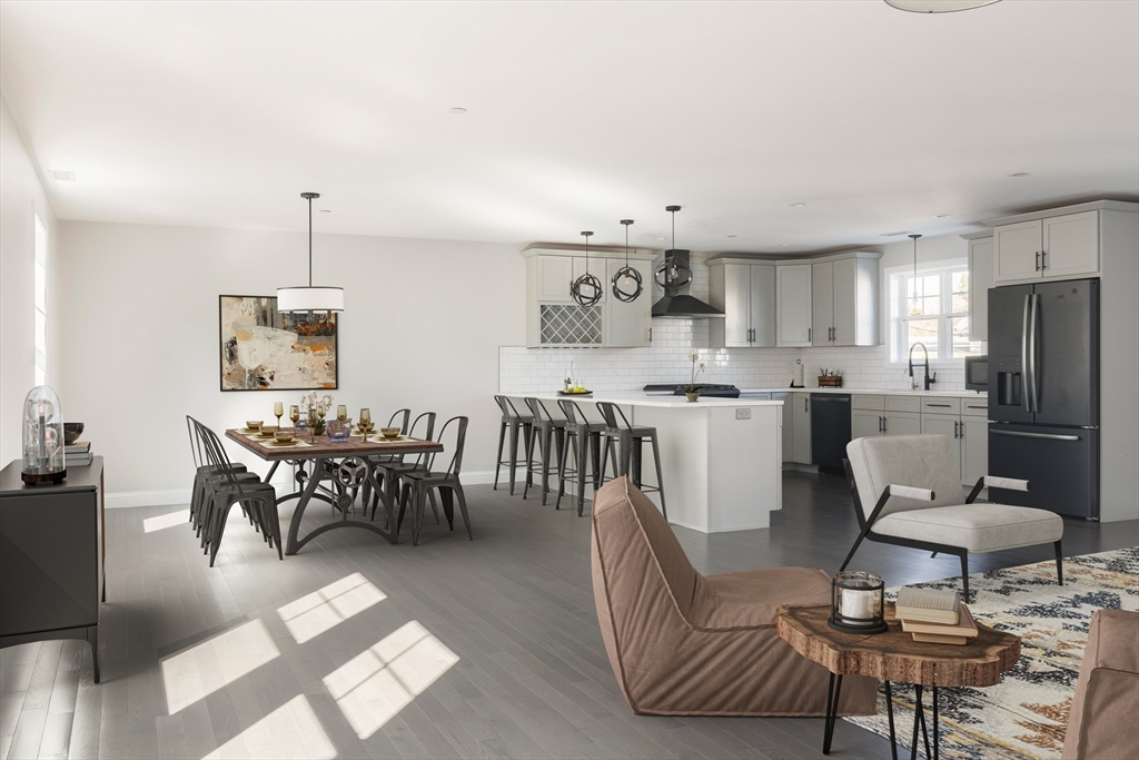 a kitchen with stainless steel appliances a dining table chairs and a refrigerator