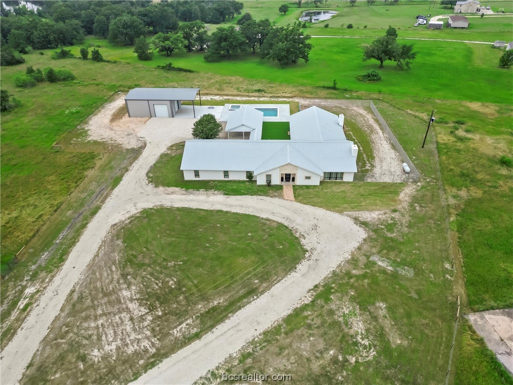 an aerial view of a house with a yard and lake view