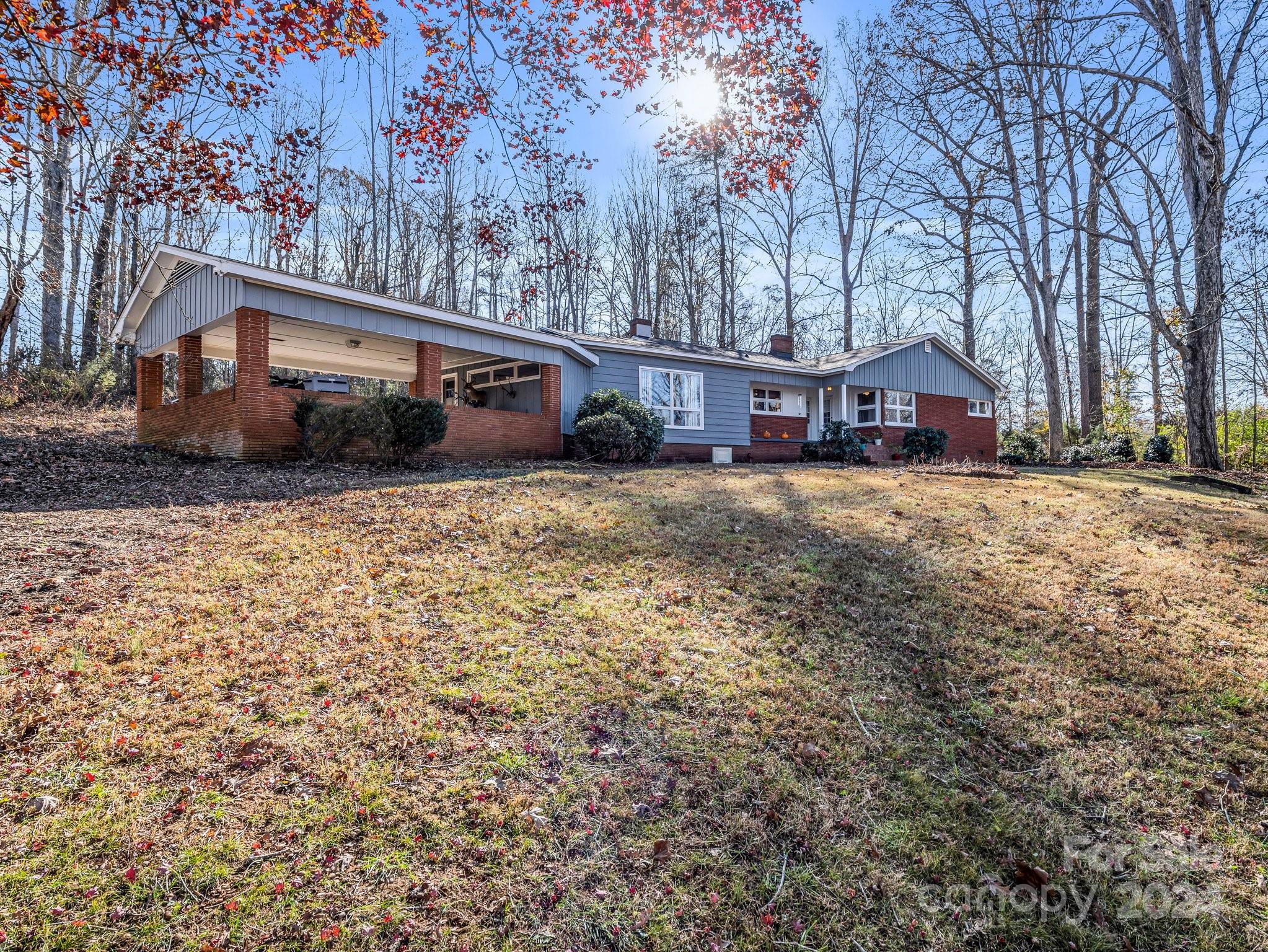 a front view of a house with a yard and trees