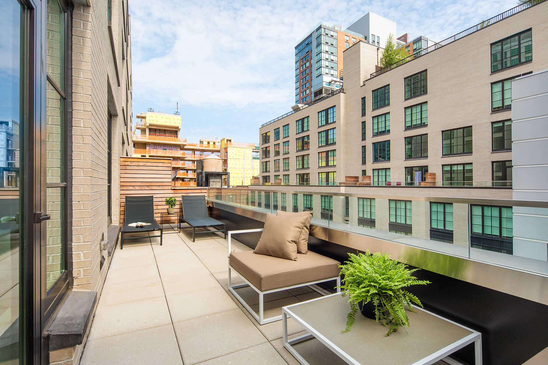 a balcony with furniture and a potted plant