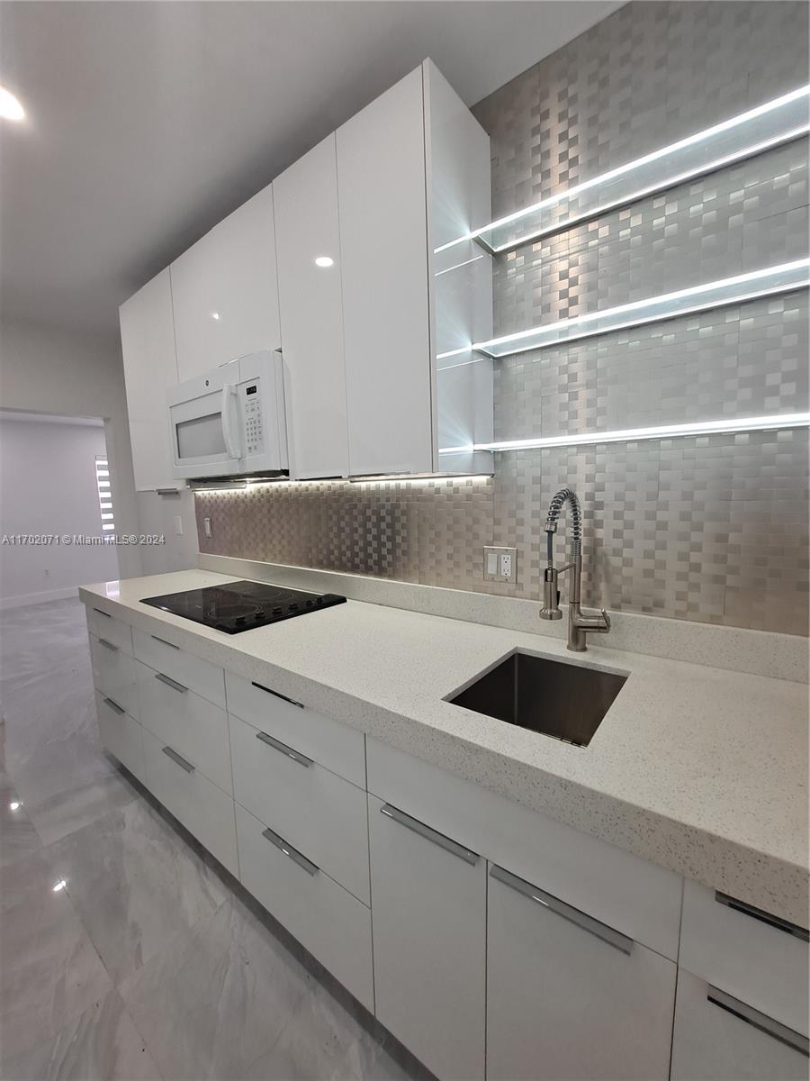 a kitchen with appliances cabinets and a sink