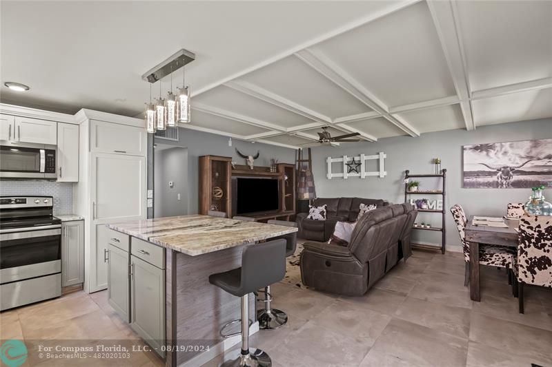 a living room with furniture and a kitchen