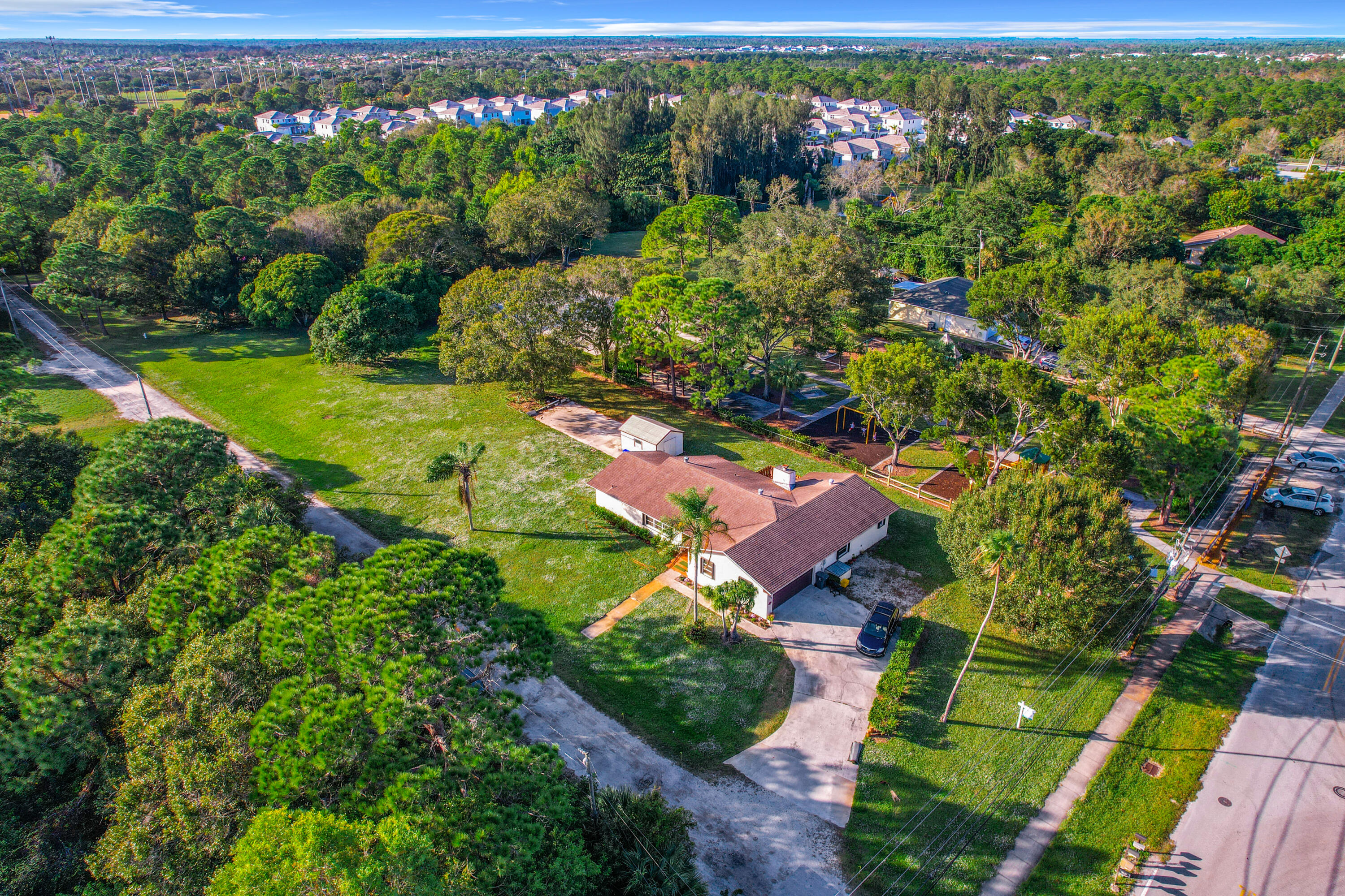 an aerial view of residential houses with outdoor space and trees