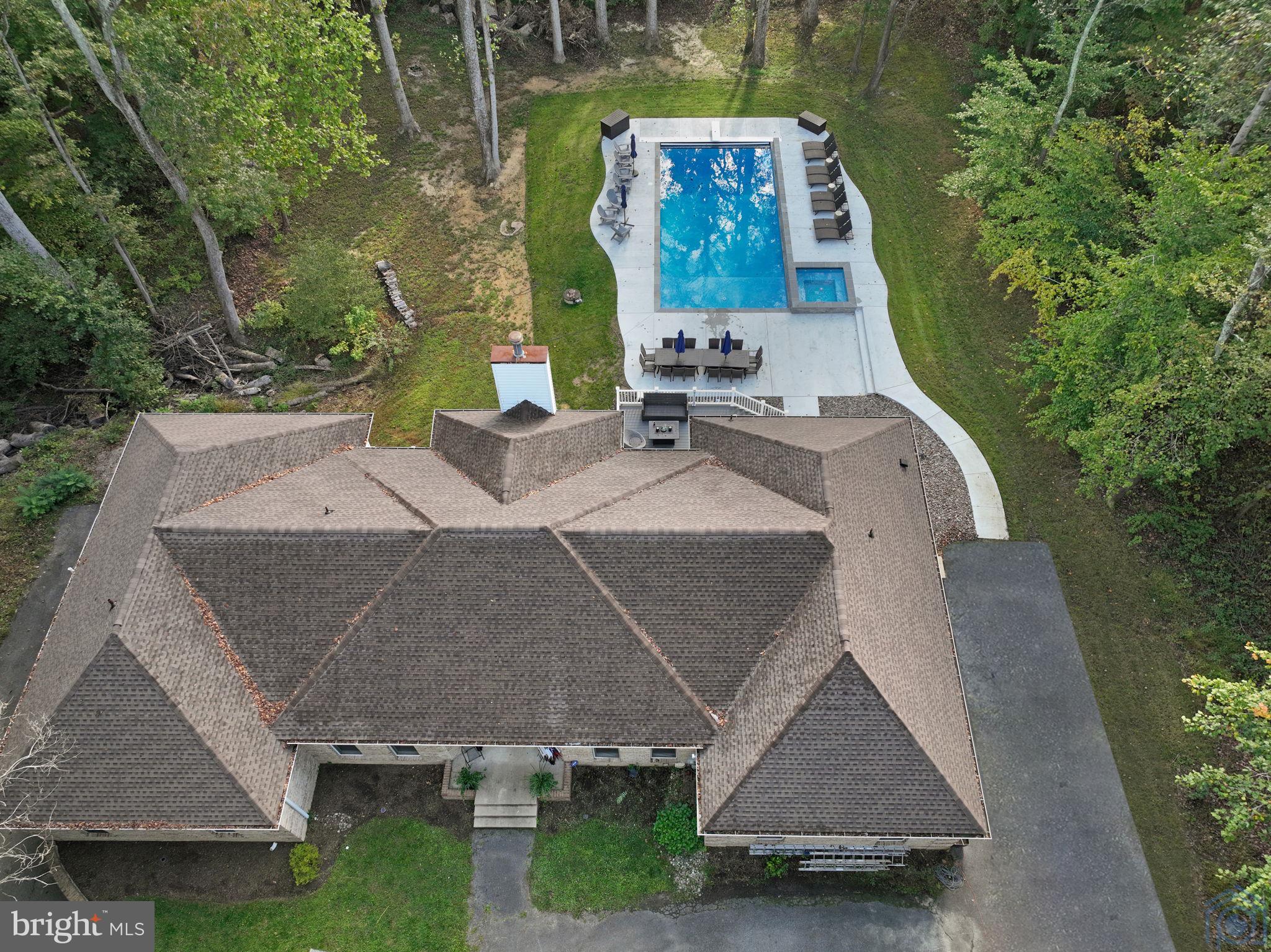 an aerial view of a house with swimming pool and big yard